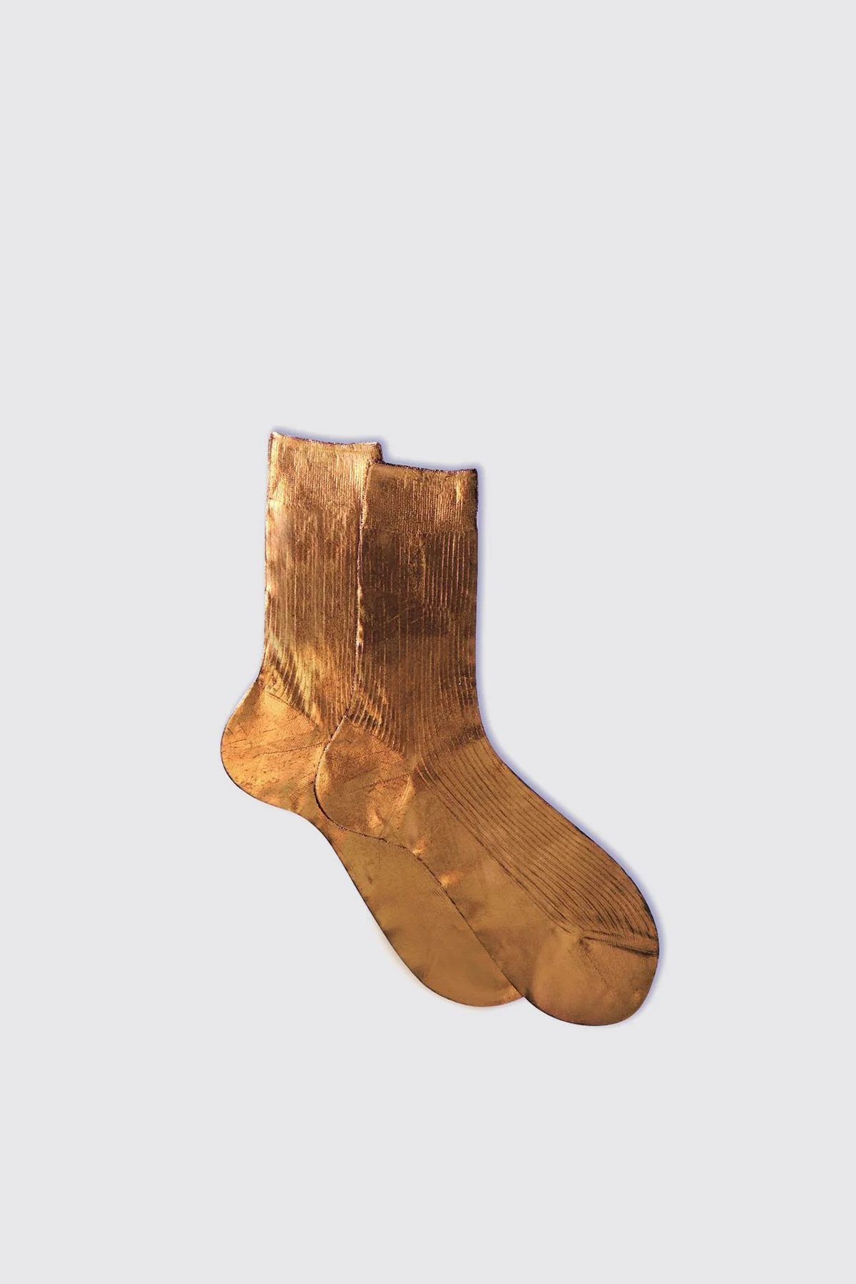 Pair of gold socks on a light gray background