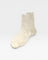 Pair of beige socks on a light gray background