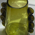 Green glass vase with decorative handles on a white background
