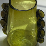 Green glass vase with decorative handles on a white background
