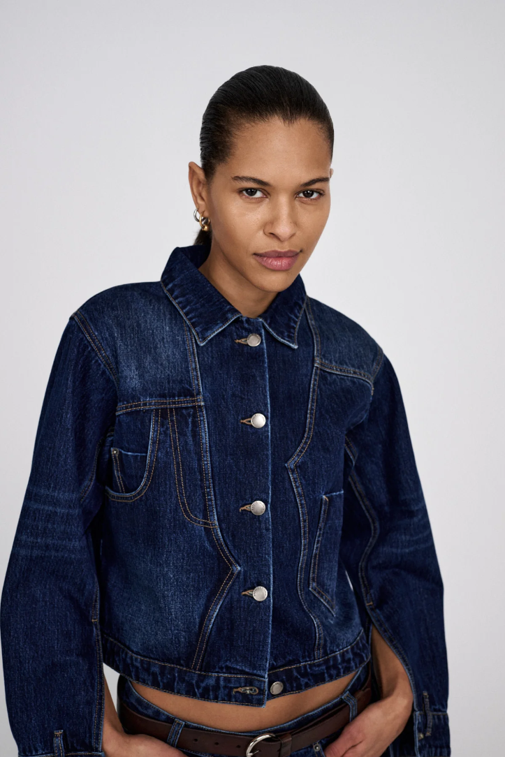 Woman wearing a blue denim jacket against a white background