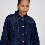 Woman wearing a blue denim jacket against a white background