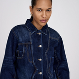 Woman wearing a blue denim jacket against a white background