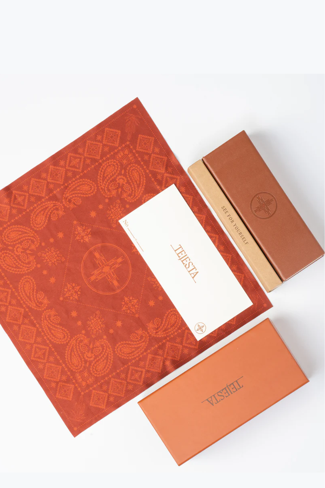 Orange patterned cleaning cloth with a white card and another orange box on a white background