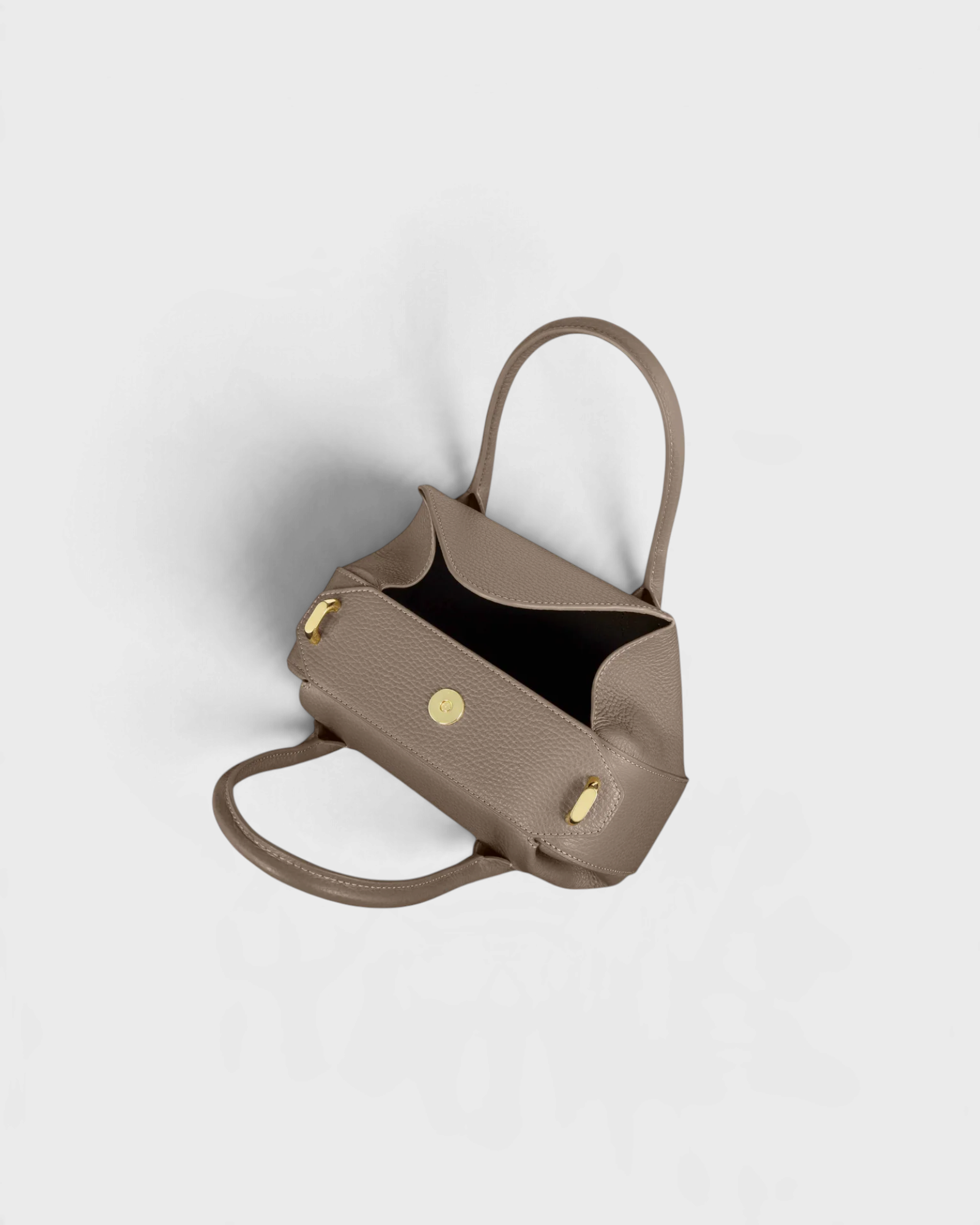 JONES + CO Oyster Mini Duffle in taupe pebble grained Italian leather with gold-tone hardware and top handles.