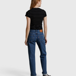 JONES + CO Lisa Tee in black with white stripes, worn by a model from behind with blue jeans and black shoes.