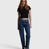 JONES + CO Lisa Tee in black with white stripes, made from recycled cotton, worn by a model with blue jeans.