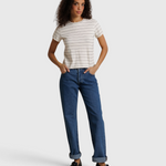 Model wearing JONES + CO Lisa Tee in natural stripe recycled cotton with blue denim jeans and black loafers