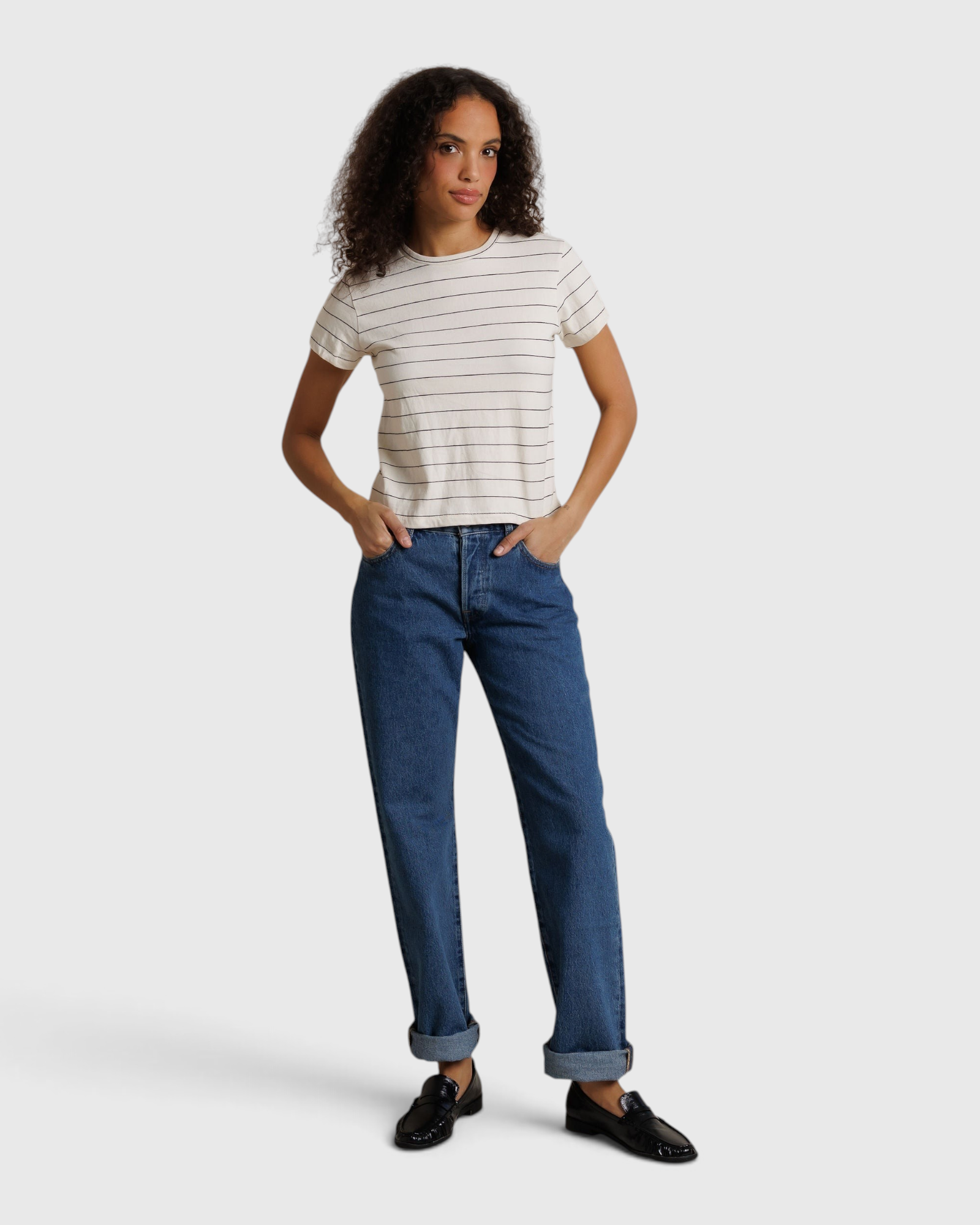 Model wearing JONES + CO Lisa Tee in natural stripe recycled cotton with blue denim jeans and black loafers