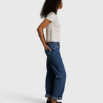 Model wearing JONES + CO Lisa Tee in natural stripe recycled cotton with blue denim jeans and black loafers