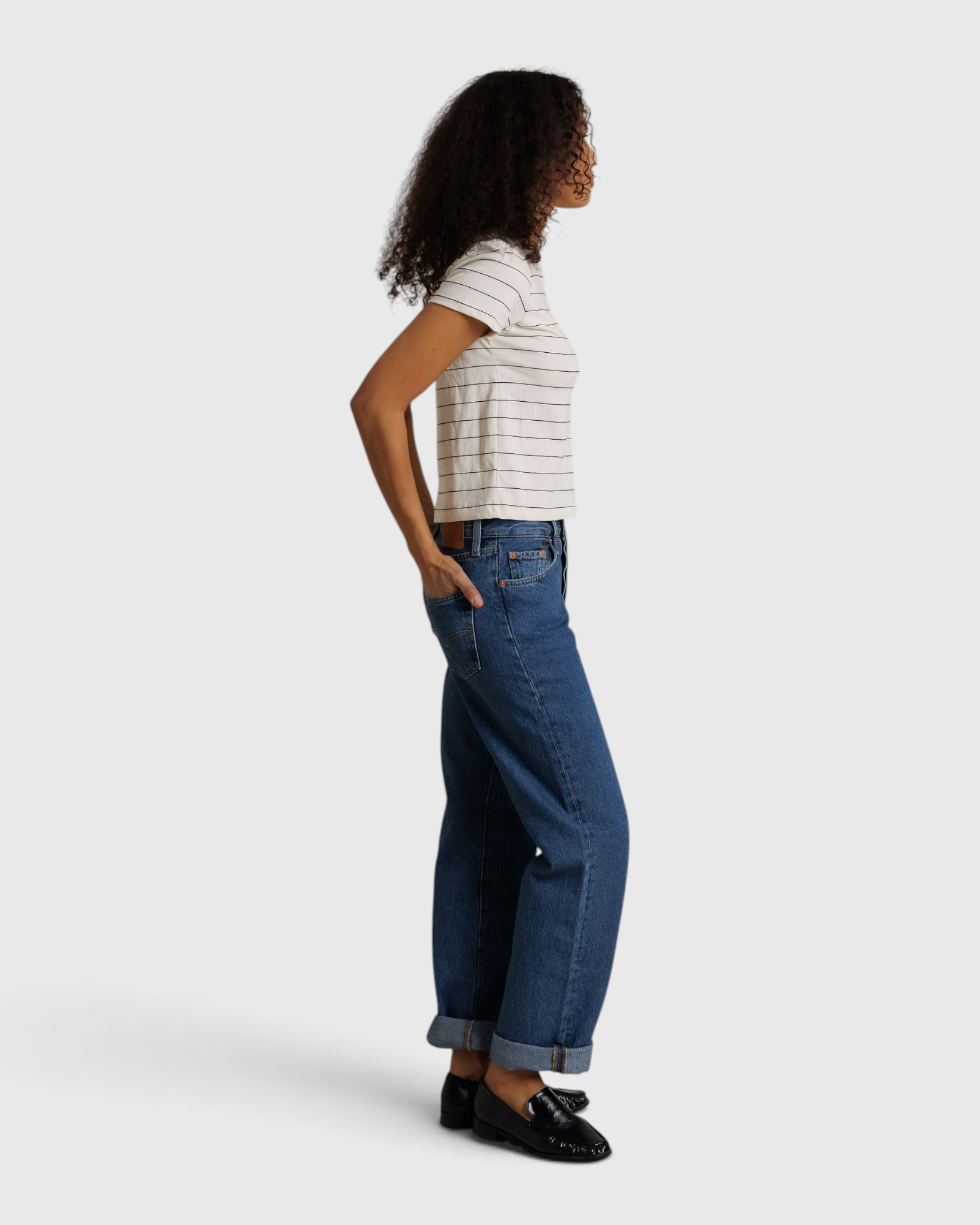 Model wearing JONES + CO Lisa Tee in natural stripe recycled cotton with blue denim jeans and black loafers