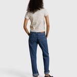 Model wearing JONES + CO Lisa Tee in natural stripe recycled cotton, paired with blue denim jeans, back view.