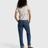 Model wearing JONES + CO Lisa Tee in natural stripe recycled cotton, paired with blue denim jeans, back view.