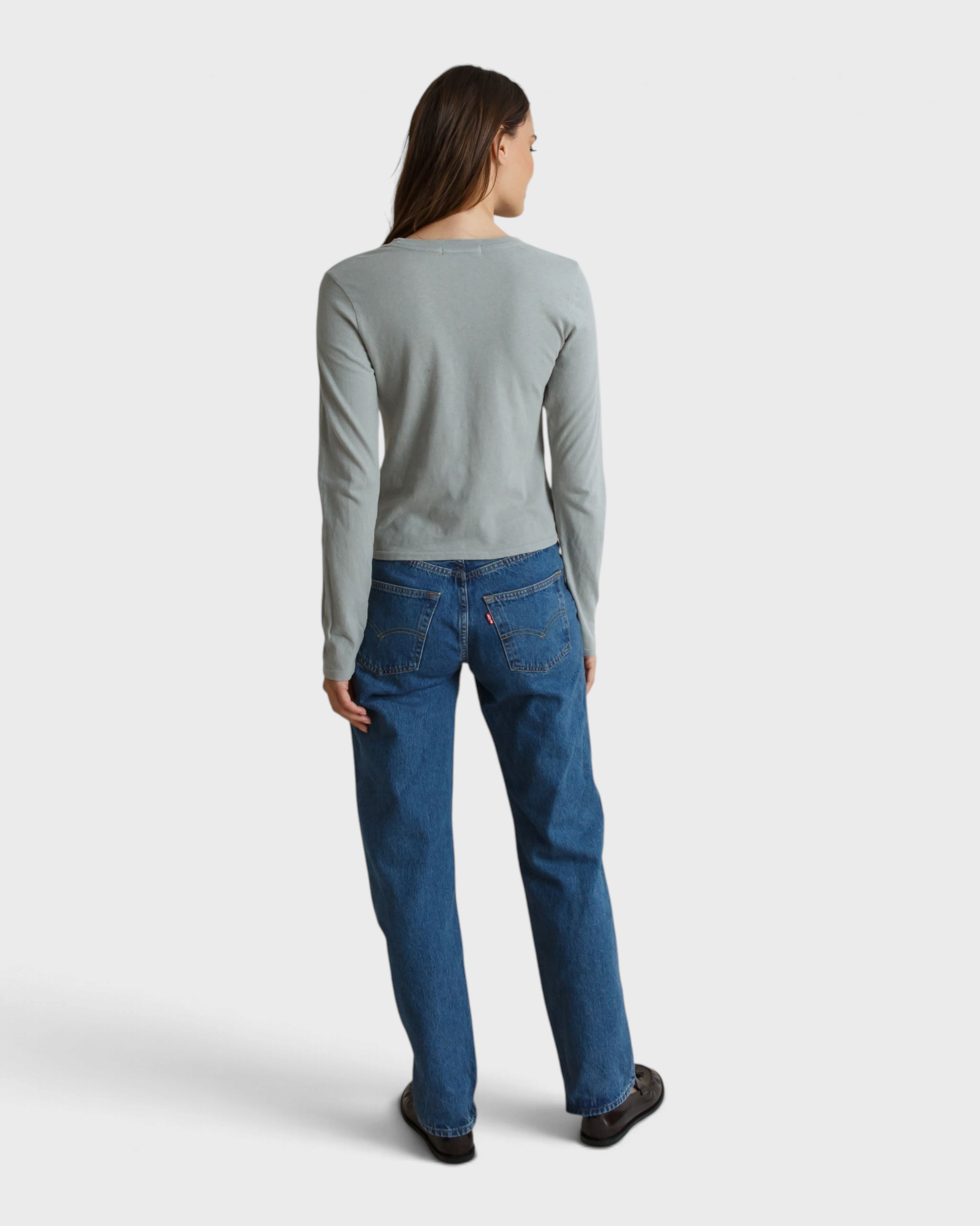 Back view of a woman wearing a JONES + CO griffin grey recycled cotton long sleeve top with blue jeans