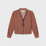 JONES + CO Lottie blouse in green, red, and cream geometric print with a V-neck and navy contrast tie detail.