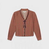JONES + CO Lottie blouse in green, red, and cream geometric print with a V-neck and navy contrast tie detail.