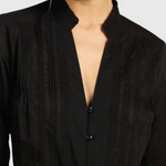 JONES + CO black Maris blouse featuring a ruffled stand collar, vertical pintuck detailing, and a button-down front.