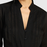 JONES + CO black Maris blouse featuring a ruffled stand collar, vertical pintuck detailing, and a button-down front.