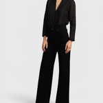 JONES + CO Maris black blouse with pintuck details, ruffled stand collar, and long sleeves on a model.