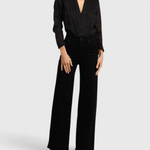 JONES + CO black Maris blouse with pintuck details, ruffled stand collar, and long sleeves on a model.