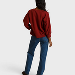 JONES + CO ruby red fleece pullover with bubble sleeves worn by a model from the back view
