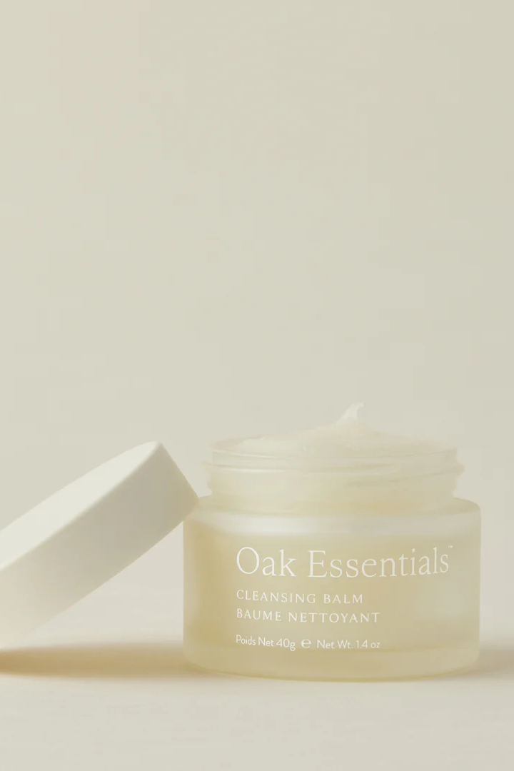 Cleansing balm jar with lid on a light beige background, featuring 'Oak Essentials' branding.