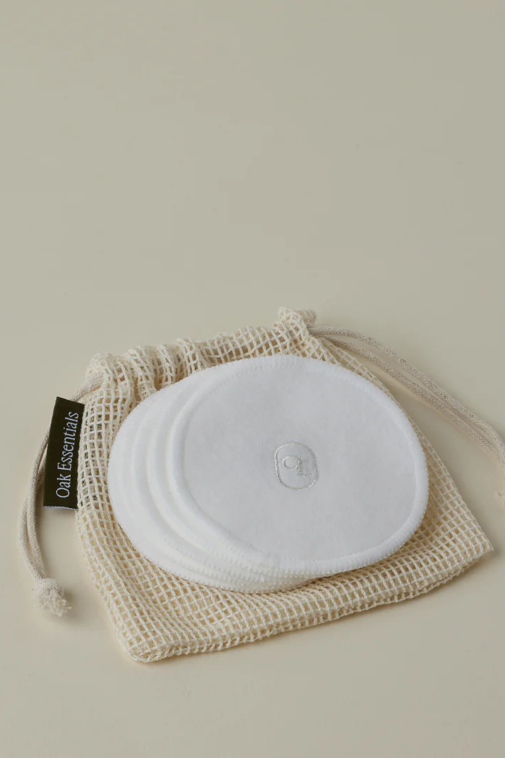 Reusable cotton pads in a mesh bag on a beige background