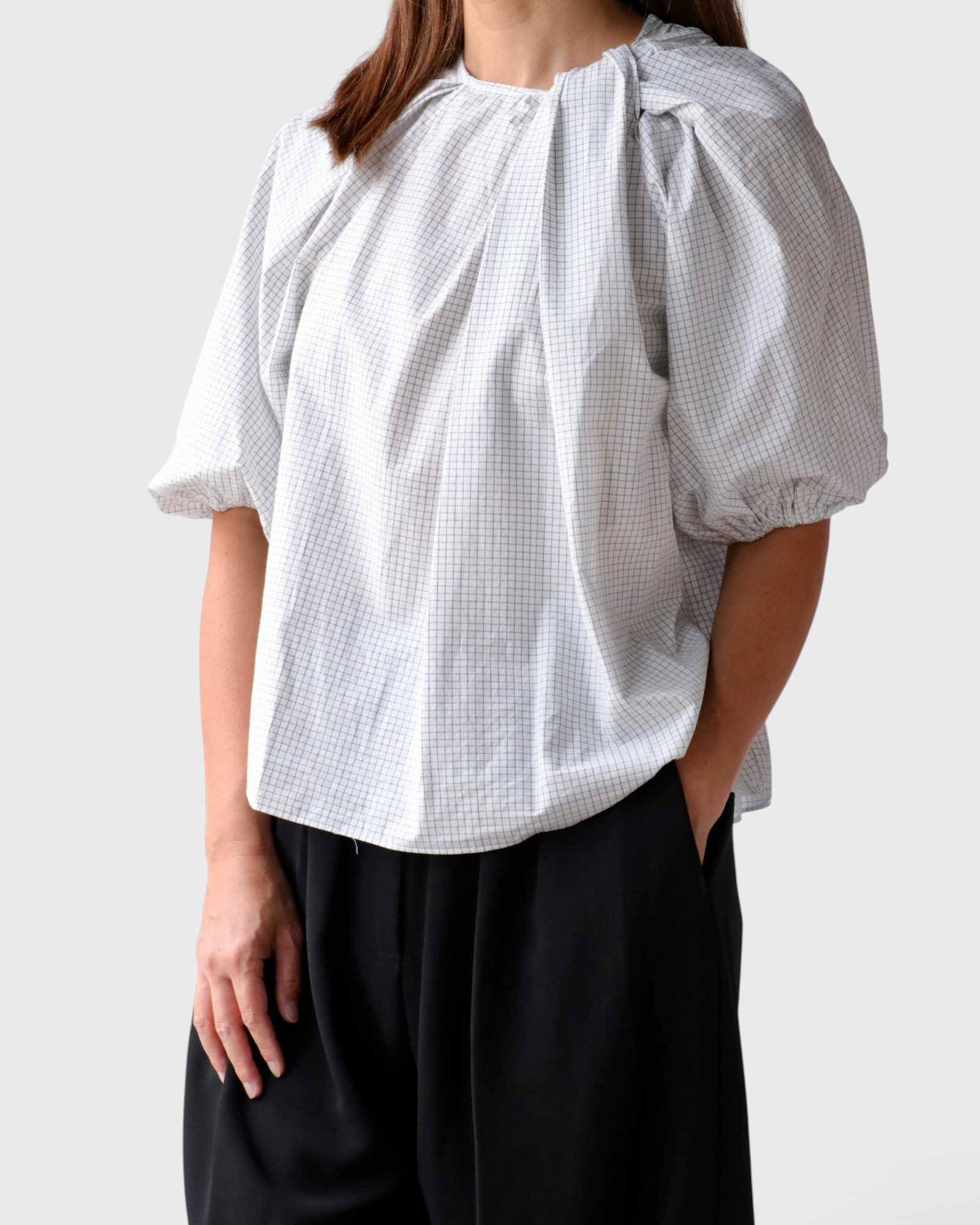 JONES + CO Lanson white crewneck top with short bubble sleeves, ruching at the neck, and a subtle grid pattern.