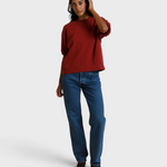 Model wearing a JONES + CO ruby red French terry sweatshirt with three-quarter puff sleeves and blue jeans