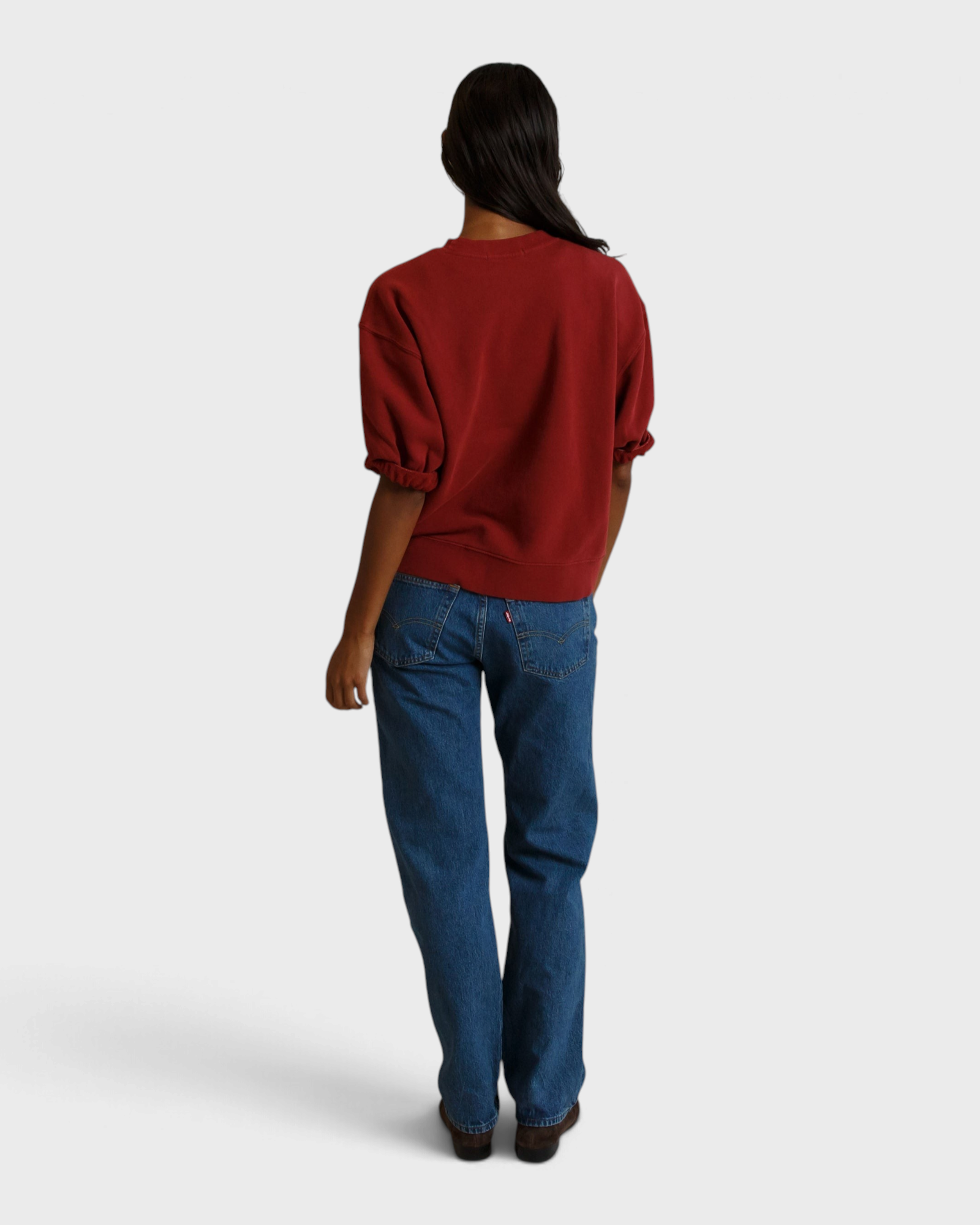 Back view of a woman wearing a JONES + CO ruby red French terry sweatshirt with three-quarter puff sleeves.