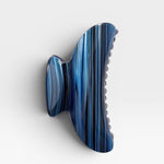Blue and black striped hair clip on a white background