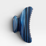 Blue and black striped hair clip on a white background