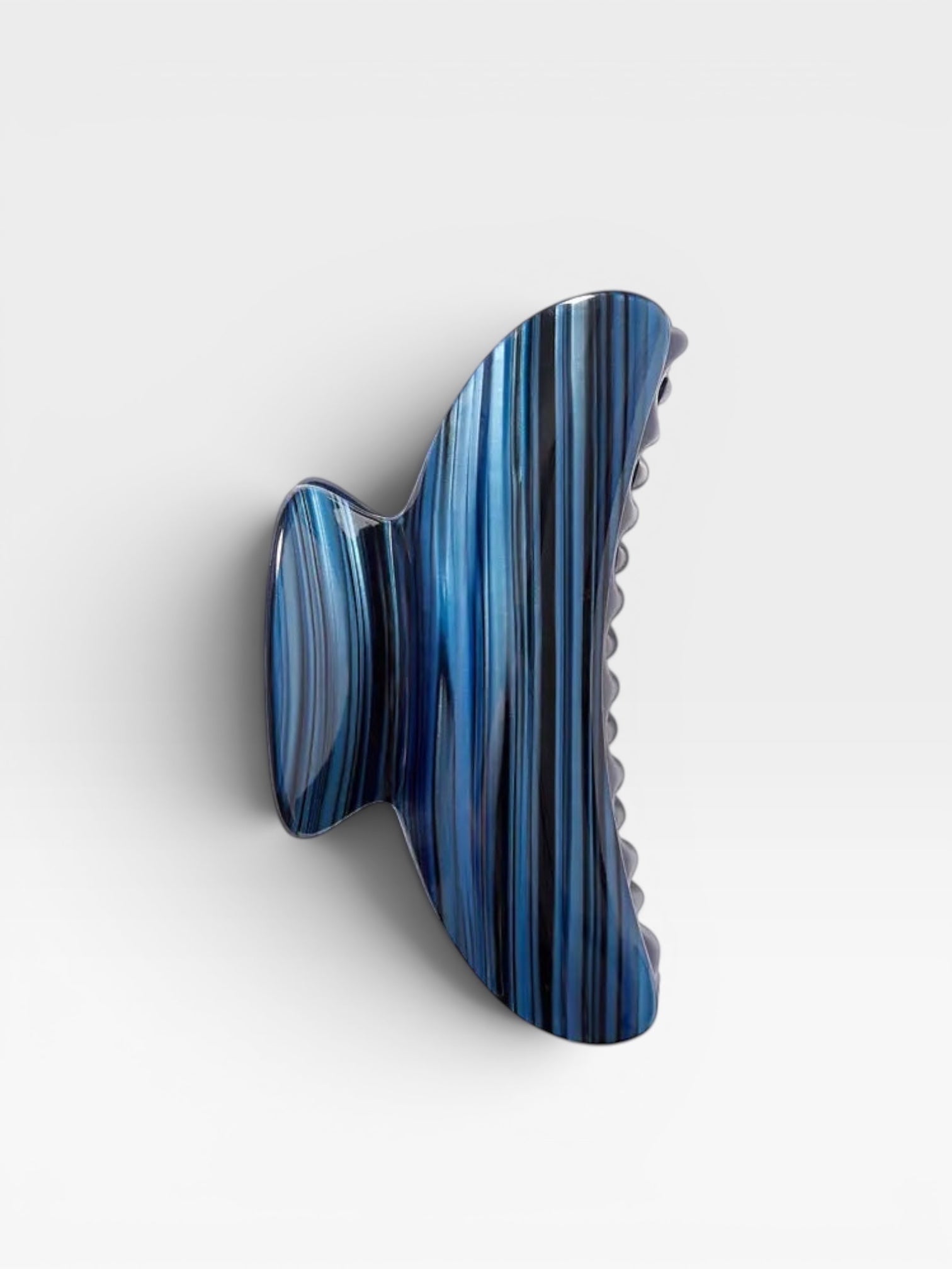 Blue and black striped hair clip on a white background