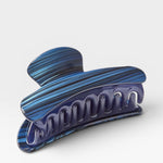 Blue and purple marbled hair clip on a white background