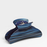 Blue and black striped hair clip on a white background