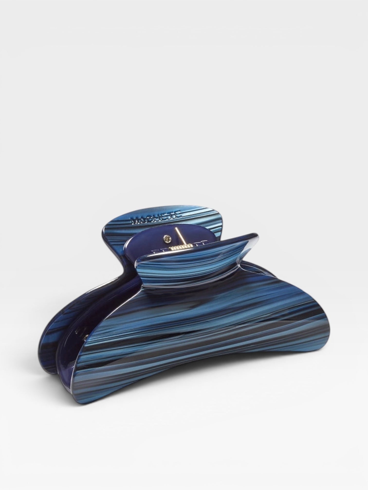 Blue and black striped hair clip on a white background