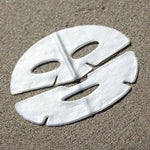 White face mask on sand