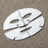 White face mask on sand