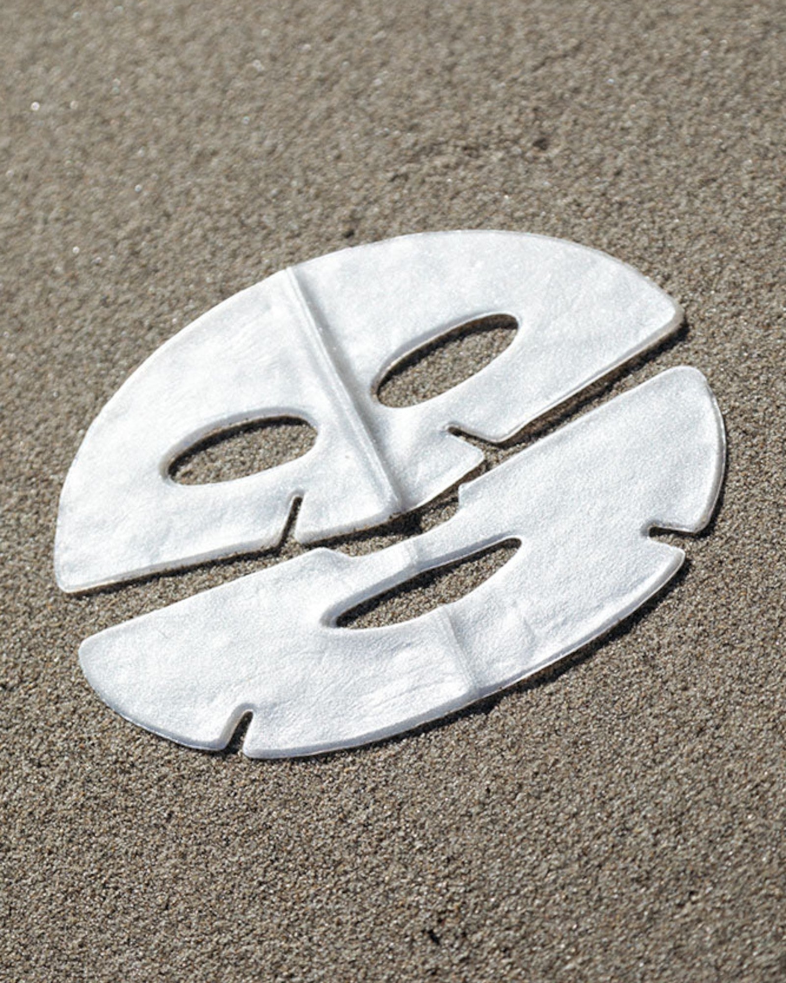 White face mask on sand