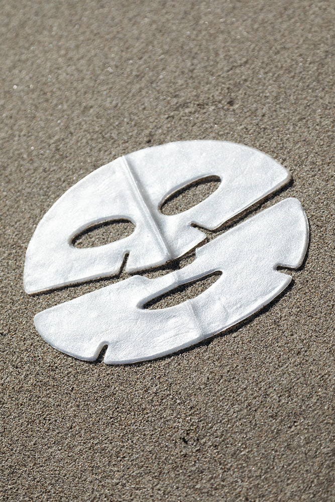 White face mask on sand