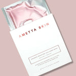Ametta Skin pink collagen mask in packaging on a light pink background