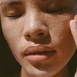 Close-up of a person's face with a sun-kissed complexion and mud mask on skin