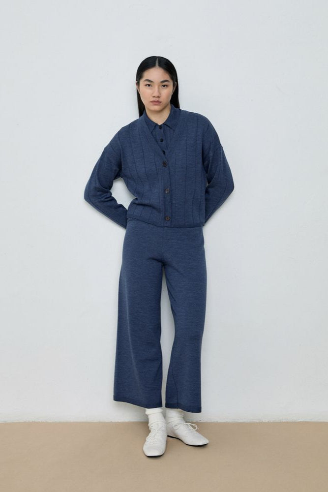 Person wearing a blue outfit with white shoes on a plain background