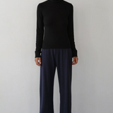 image of model in black turtleneck and blue pants from a distance