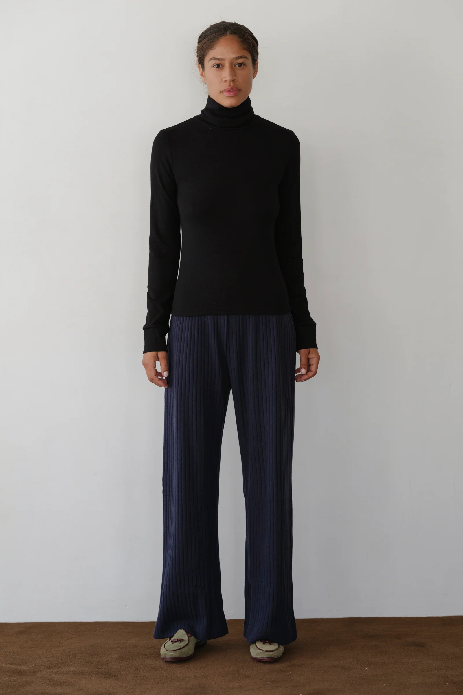 image of model in black turtleneck and blue pants from a distance