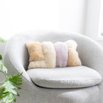 Colorblock fuzzy pillow on a grey round chair