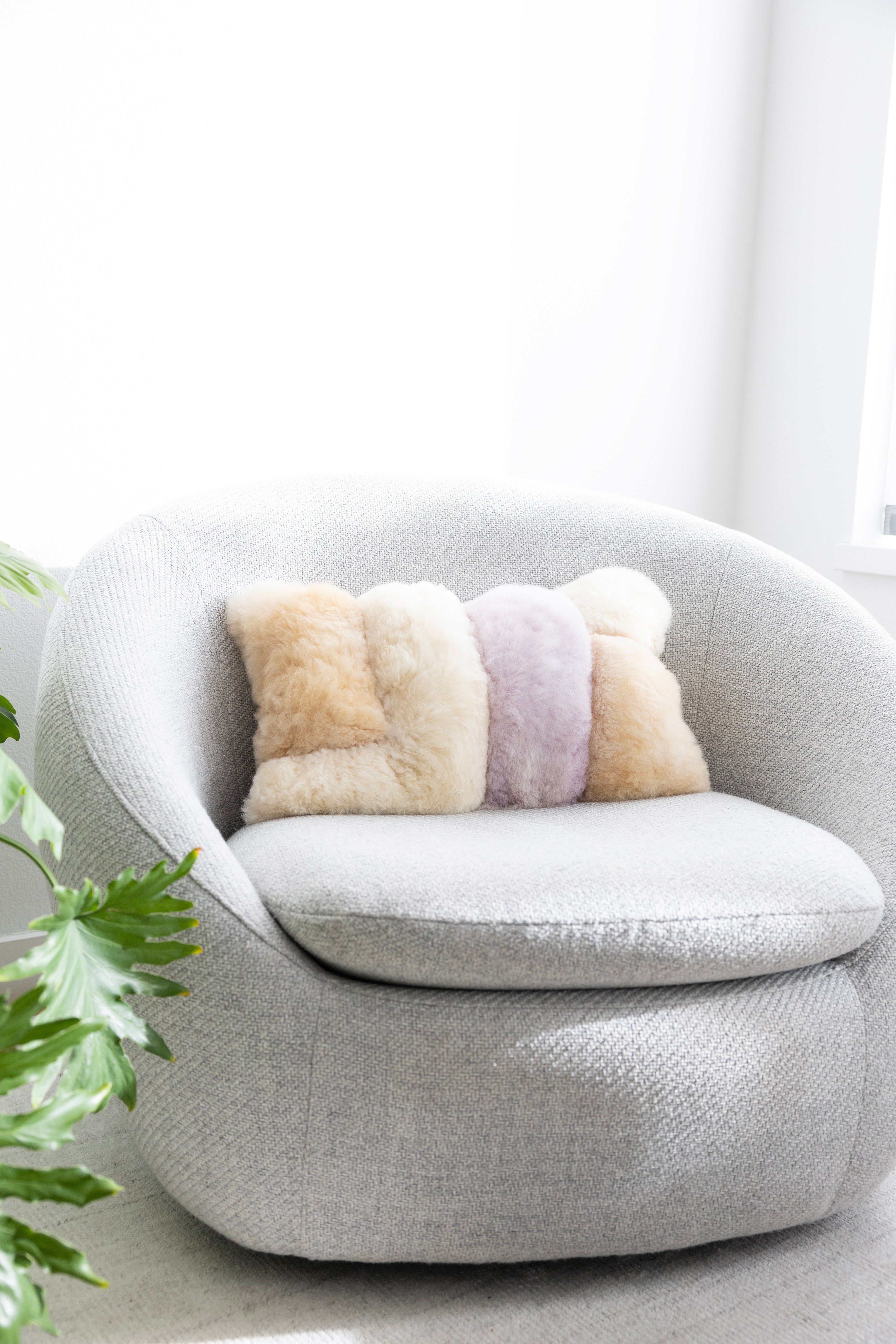 Colorblock fuzzy pillow on a grey round chair