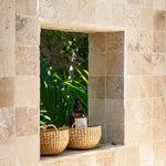 Two woven baskets sitting in a window sill
