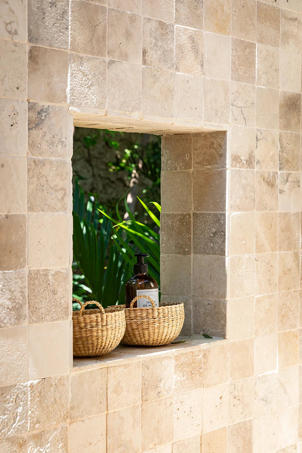 Two woven baskets sitting in a window sill