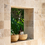 Two woven baskets sitting in a window sill